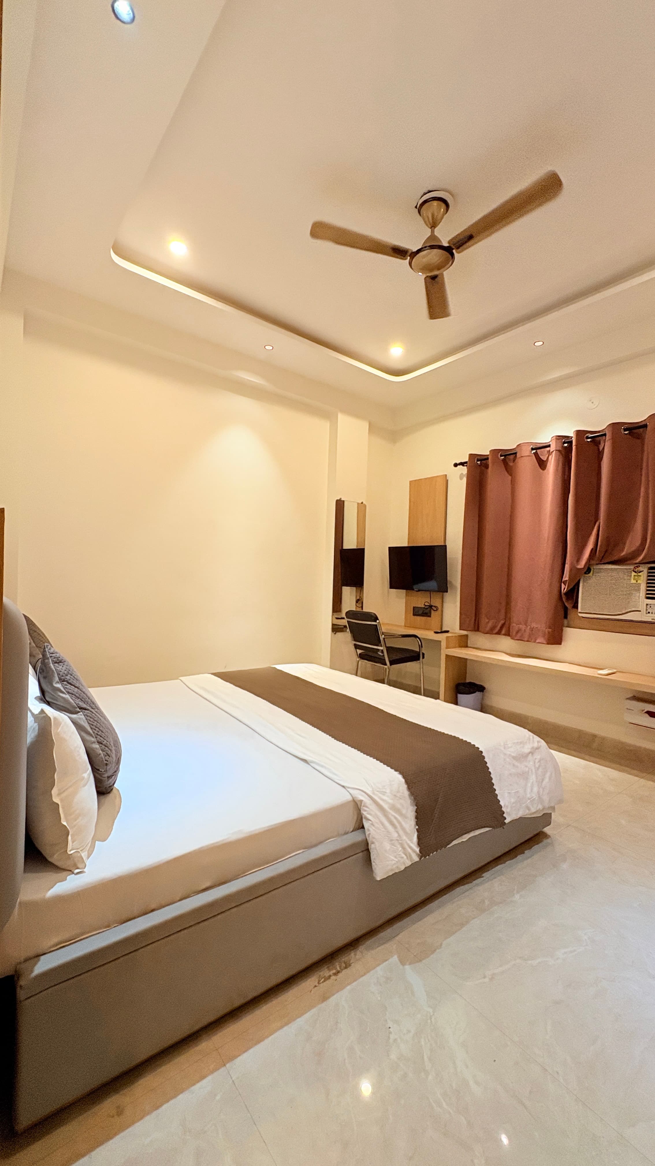 Workspace, wall-mounted television, and double bed