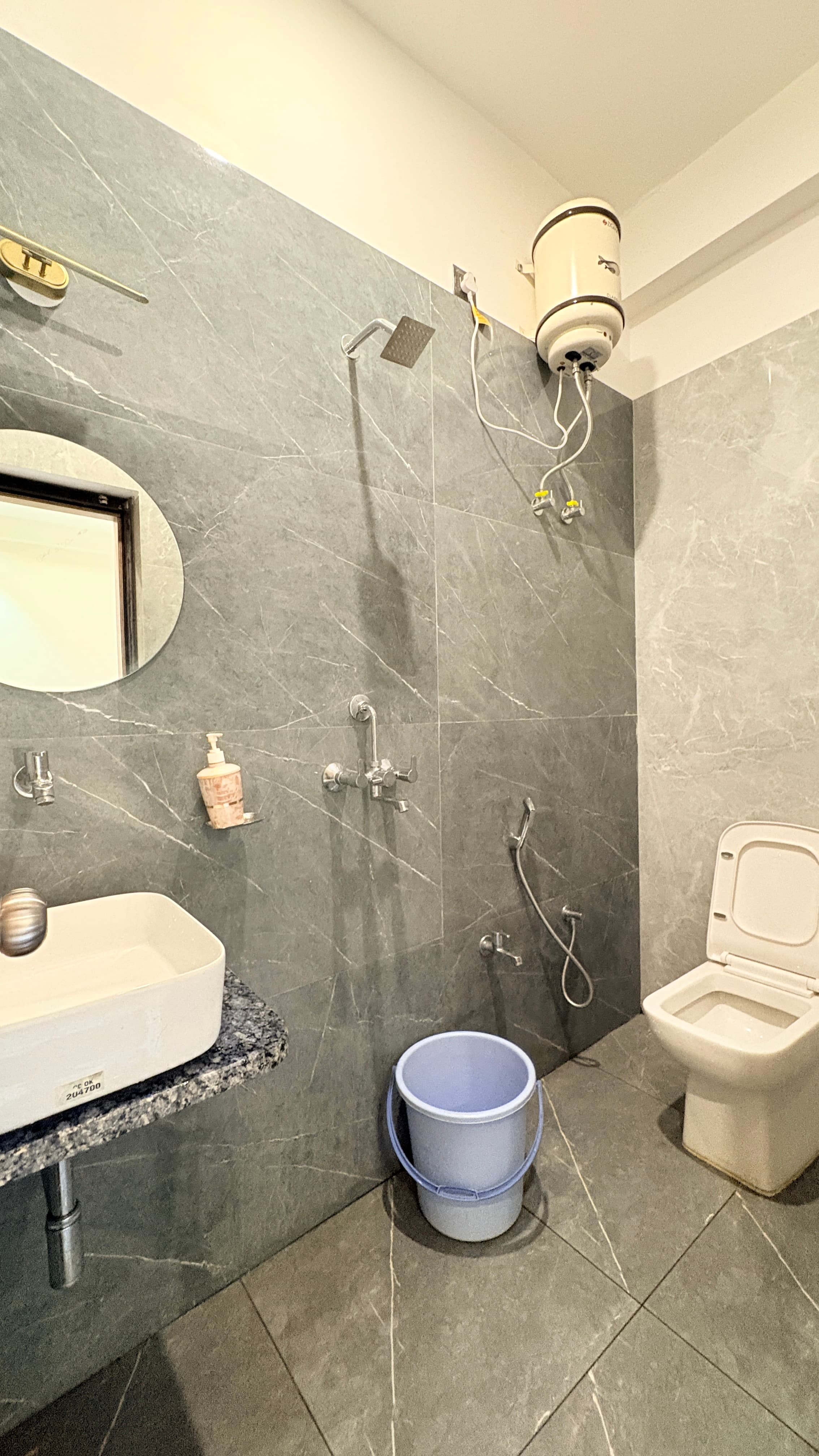 Attached bathroom with marble-look tiles and rainfall shower