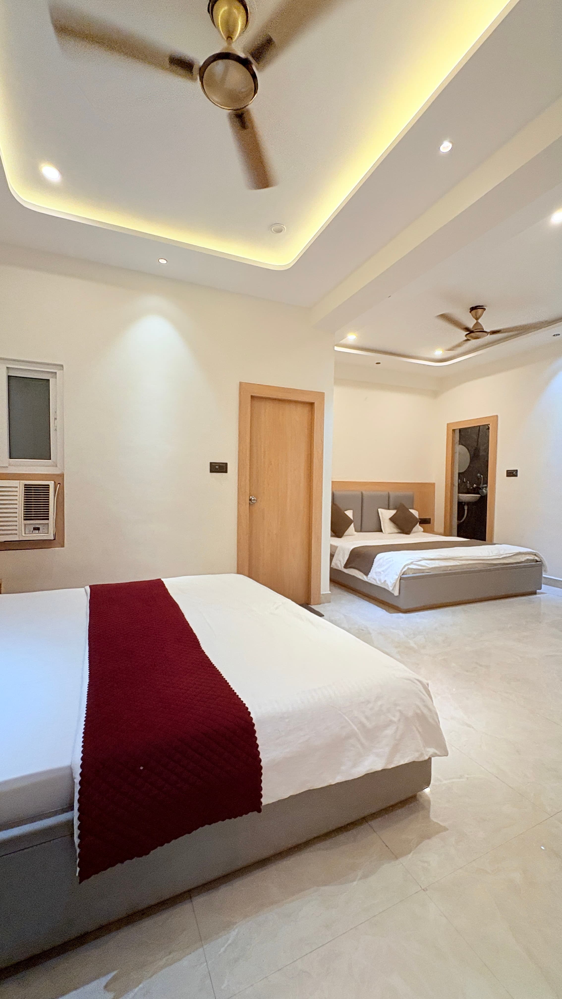 Two beds under gold-toned ceiling fans in the family room