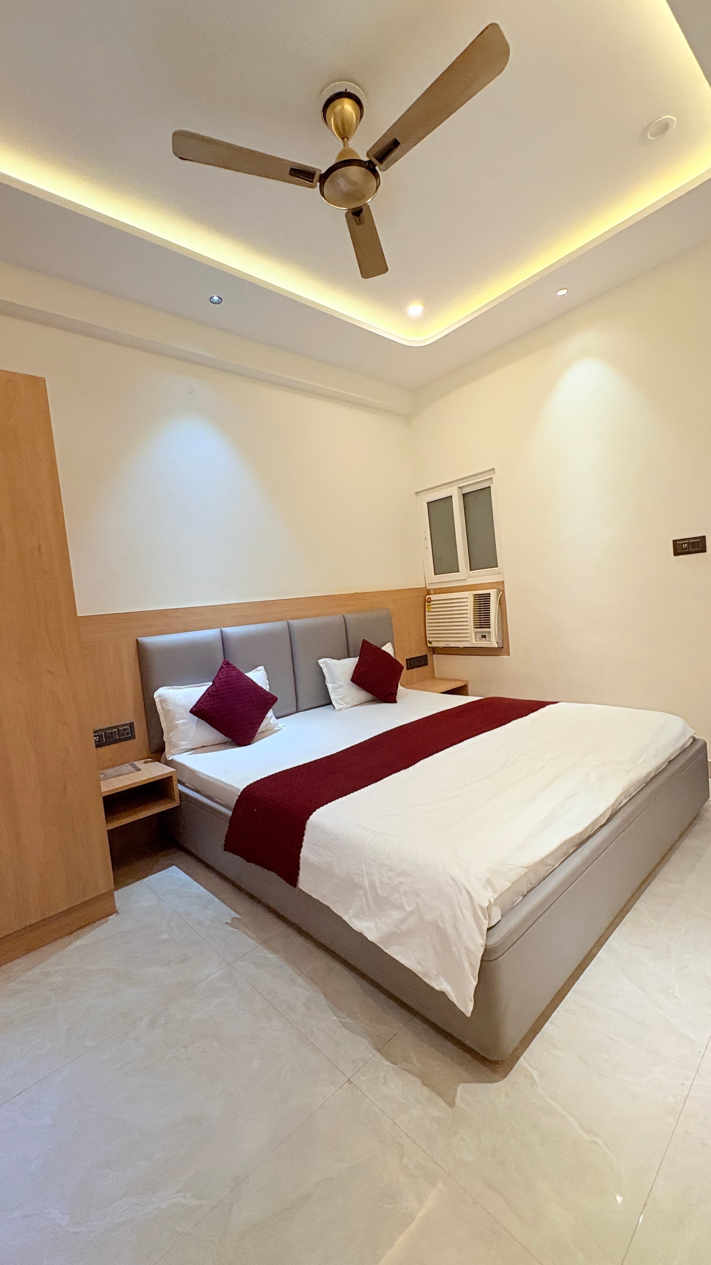 Premium room at Kailas Residency with white linen and a maroon runner